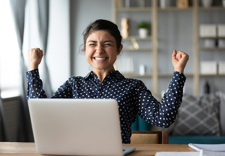 Euphoric young indian girl celebrate online victory triumph with laptop Our Benefits